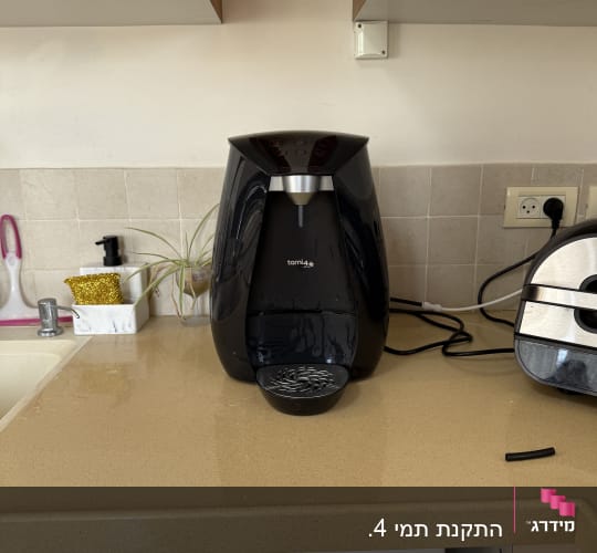 מכונת קפה על השיש במטבח עם כיור וברז
